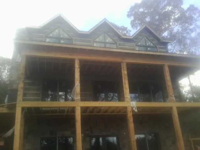 Dormers and porch framing on a large log home under construction — Roof Coating work by our crew in Cache Junction